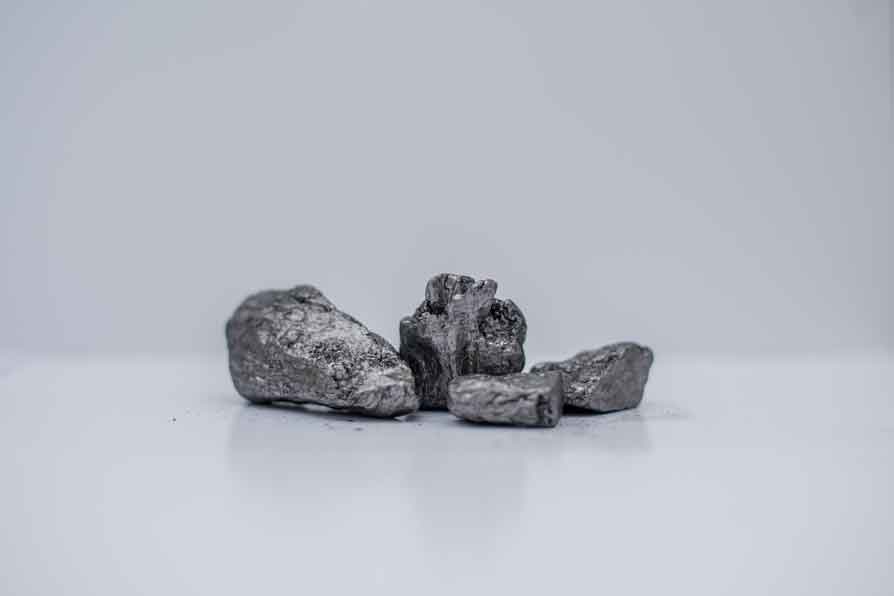Lump vein graphite pieces on a white surface.